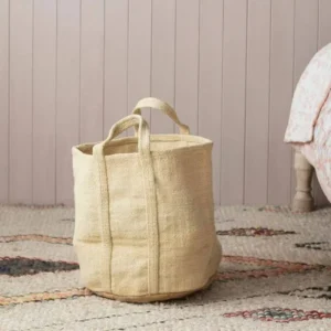 Handwoven jute storage basket with handles on rug